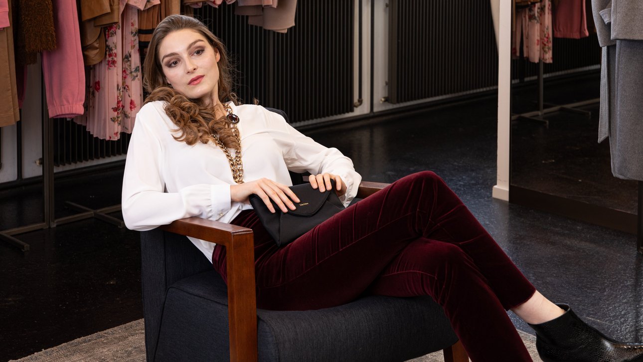 Junge Frau sitzend auf Sessel in MXM Outfit