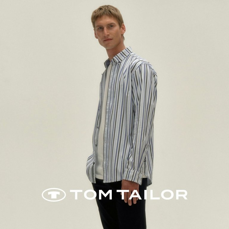 Frau in hellem Tom Tailor Herbst-Outfit