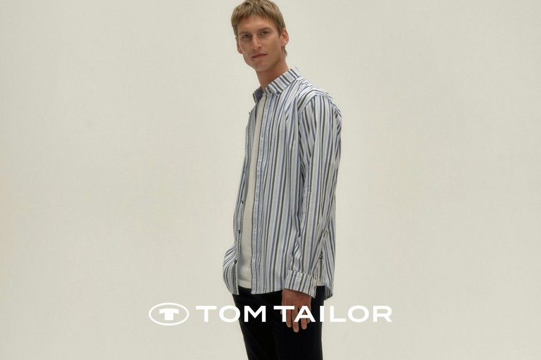 Frau in hellem Tom Tailor Herbst-Outfit