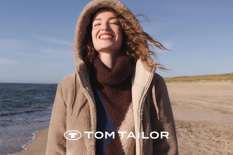 Frau in hellem Tom Tailor Herbst-Outfit
